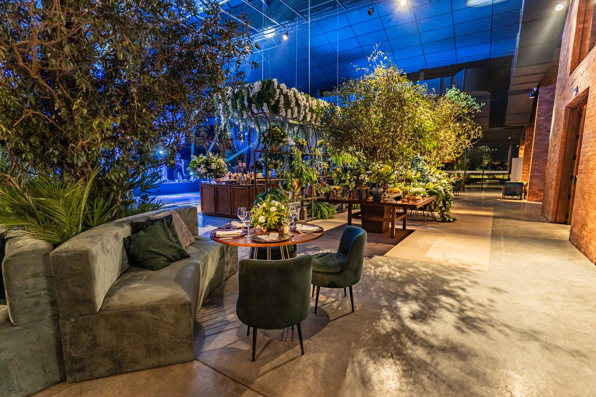 A venue being prepared with themed event tables, dressing and warm directional lighting