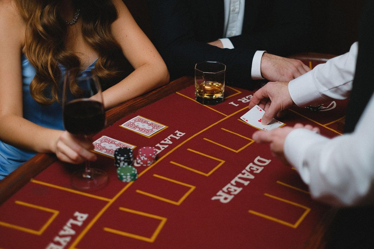 Adult guests in evening wear enjoying a private party beside a casino-themed table