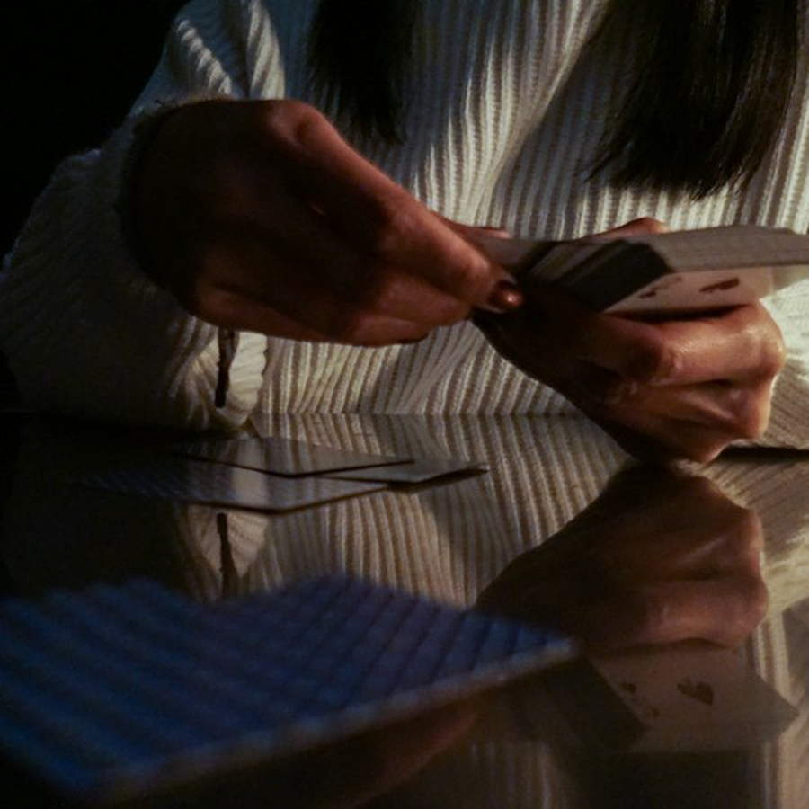 A croupier's hands dealing cards cleanly across a themed event table